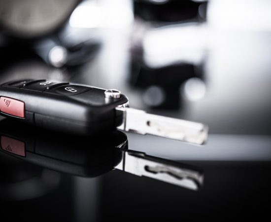 New Car Keys Closeup. Brand New Vehicle Purchase Concept. Dealership Sale Desk.